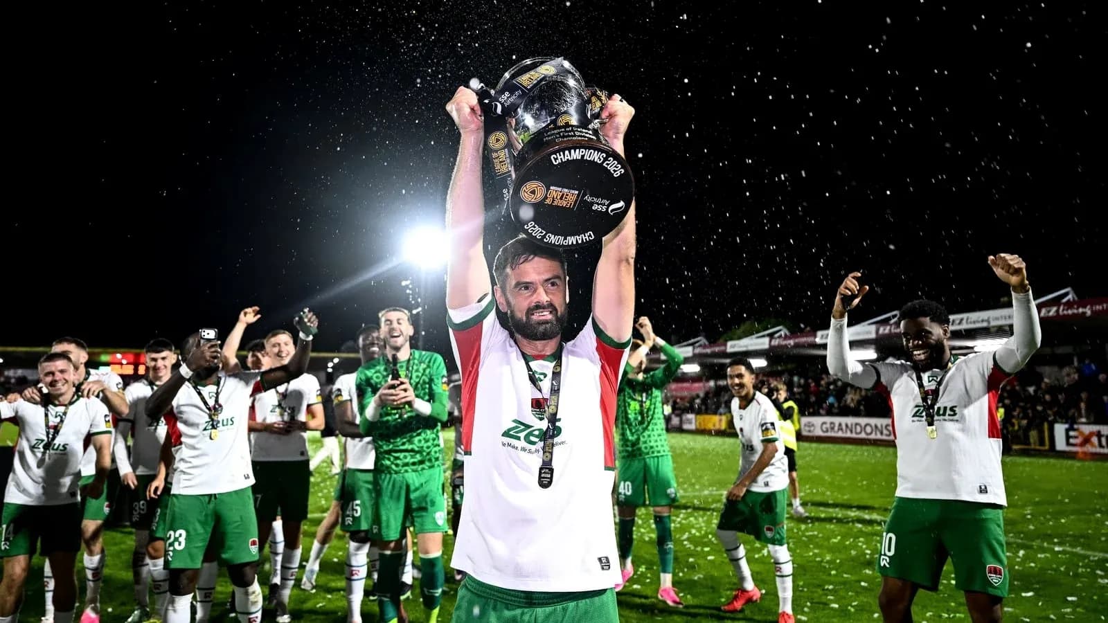 Jugador levantando el trofeo de campeones con su equipo Jugador levantando el trofeo de campeones con su equipo