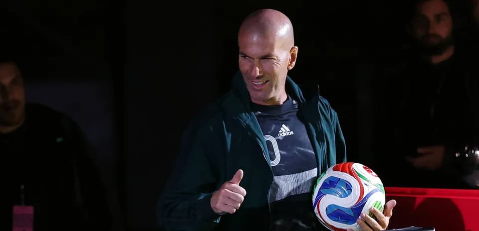 Zinedine Zidane sosteniendo un balón de fútbol Zinedine Zidane sosteniendo un balón de fútbol