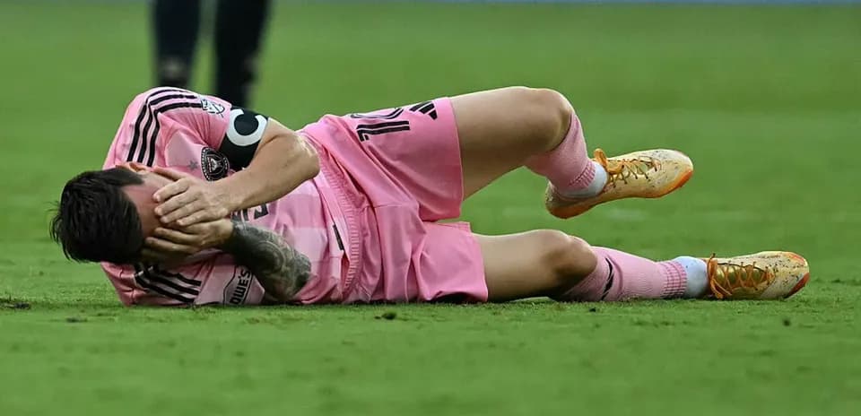 Jugador caído en el campo, sosteniendo su cabeza Jugador caído en el campo, sosteniendo su cabeza