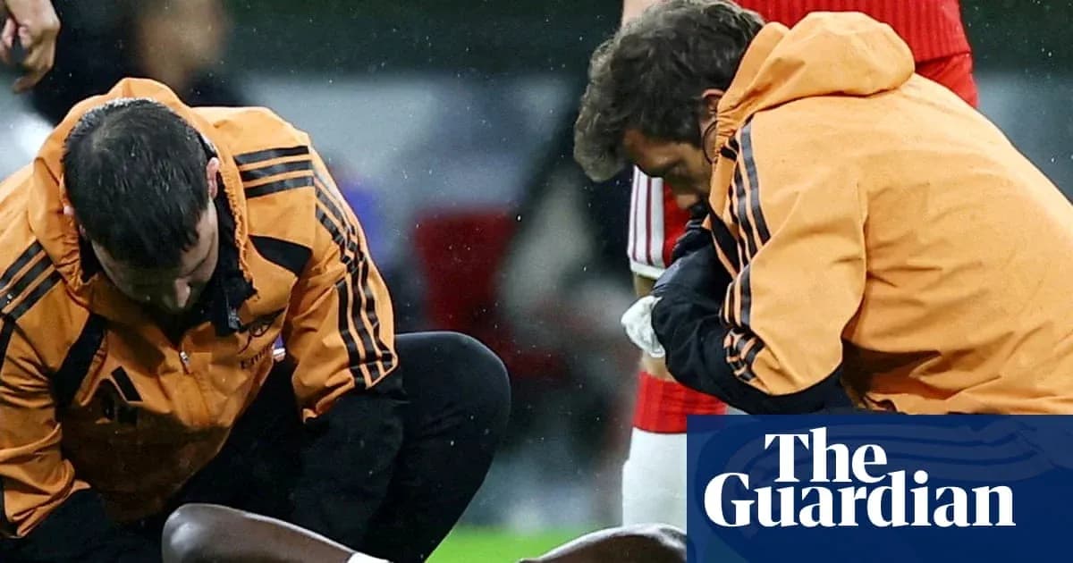 Dos entrenadores atendiendo a un jugador lesionado Dos entrenadores atendiendo a un jugador lesionado