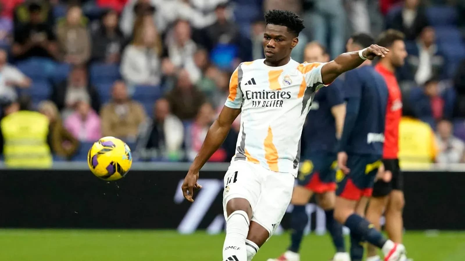 Jugador de Real Madrid pateando un balón en el campo Jugador de Real Madrid pateando un balón en el campo