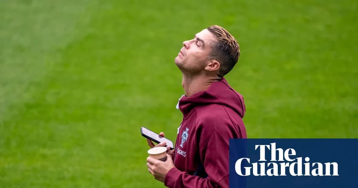 Jugador sosteniendo un teléfono y un vaso en el campo Jugador sosteniendo un teléfono y un vaso en el campo