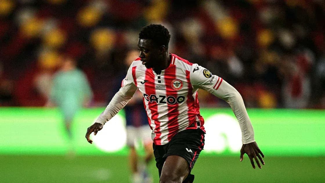 Jugador de Brentford corriendo con balón en el campo Jugador de Brentford corriendo con balón en el campo