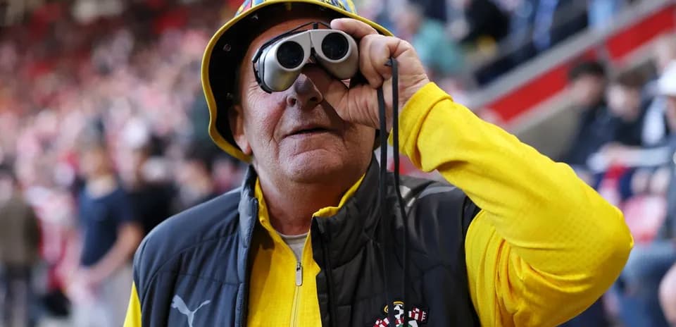 A fan wearing binoculars at a football match A fan wearing binoculars at a football match