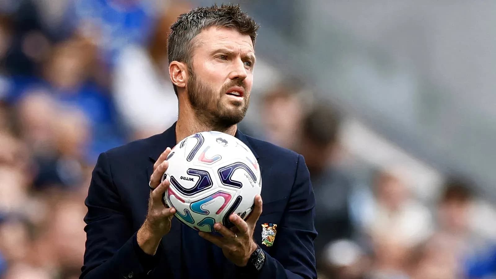 Entrenador sosteniendo un balón de fútbol en el banquillo Entrenador sosteniendo un balón de fútbol en el banquillo