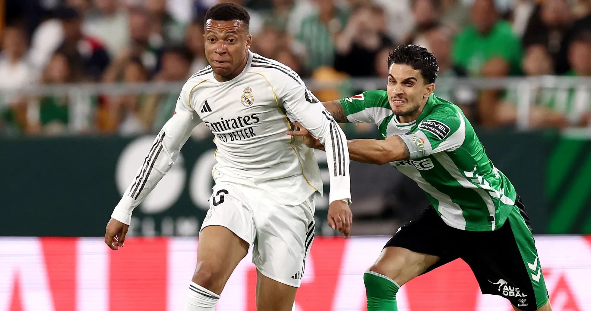 Jugador de Real Madrid driblando a rival de Betis Jugador de Real Madrid driblando a rival de Betis