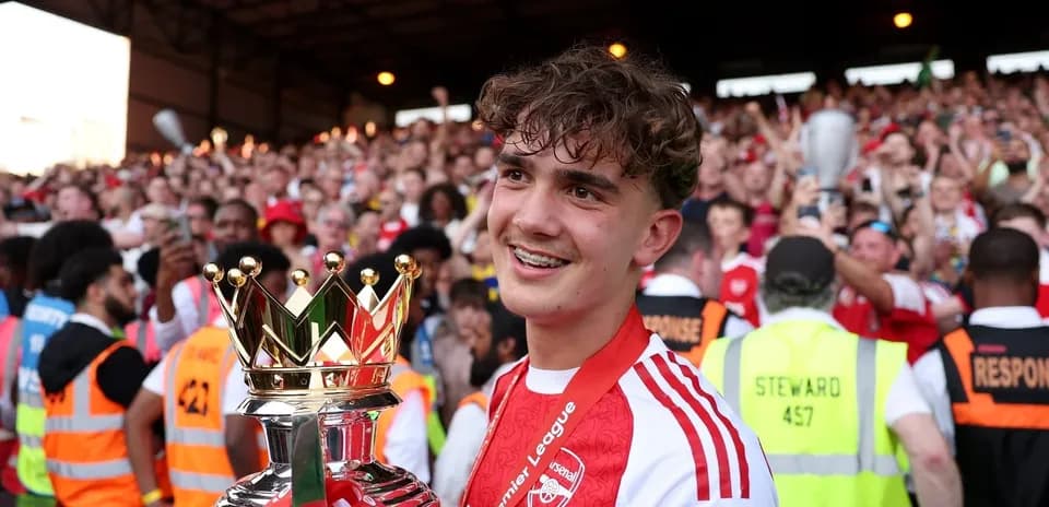 Jugador sosteniendo trofeo de la Premier League Jugador sosteniendo trofeo de la Premier League