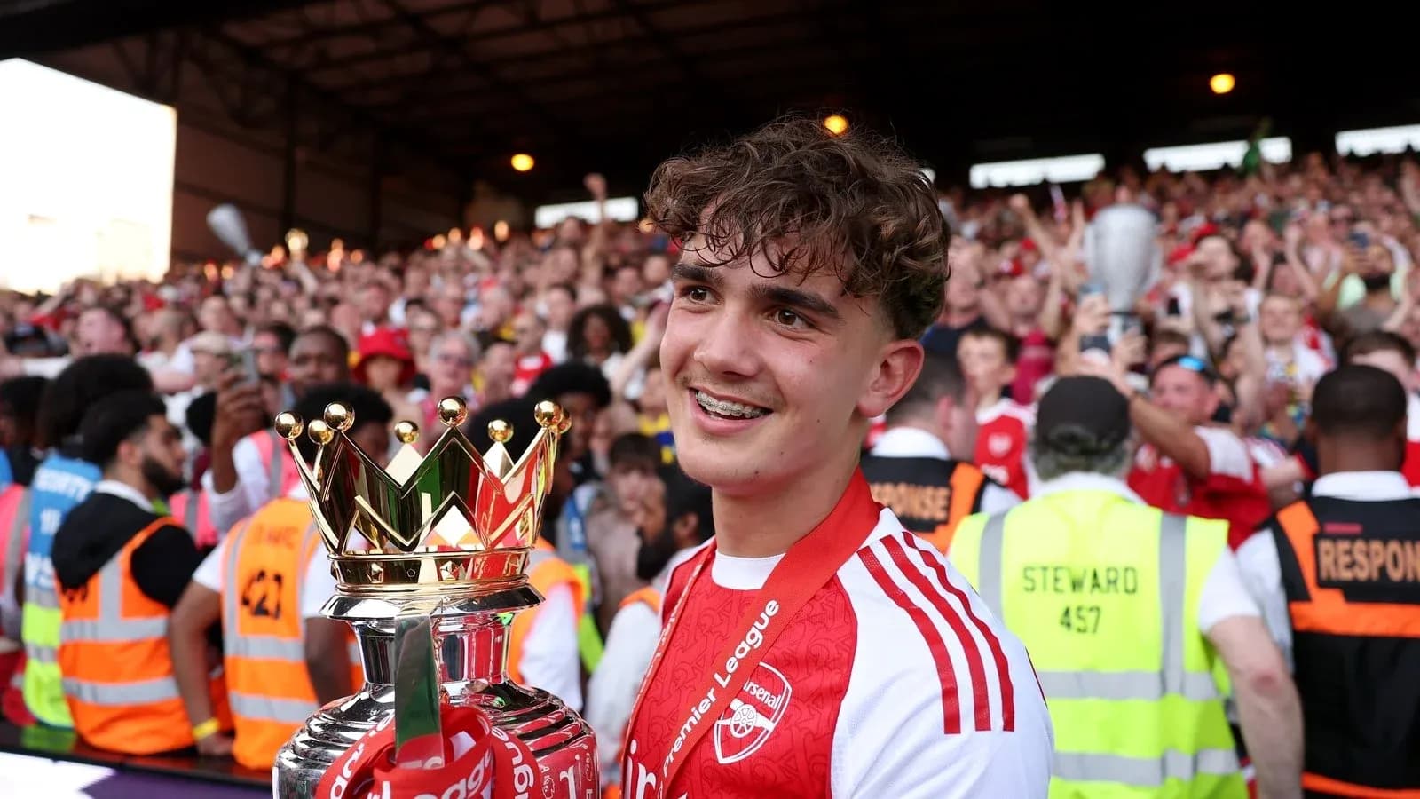 Jugador sosteniendo trofeo de la Premier League Jugador sosteniendo trofeo de la Premier League