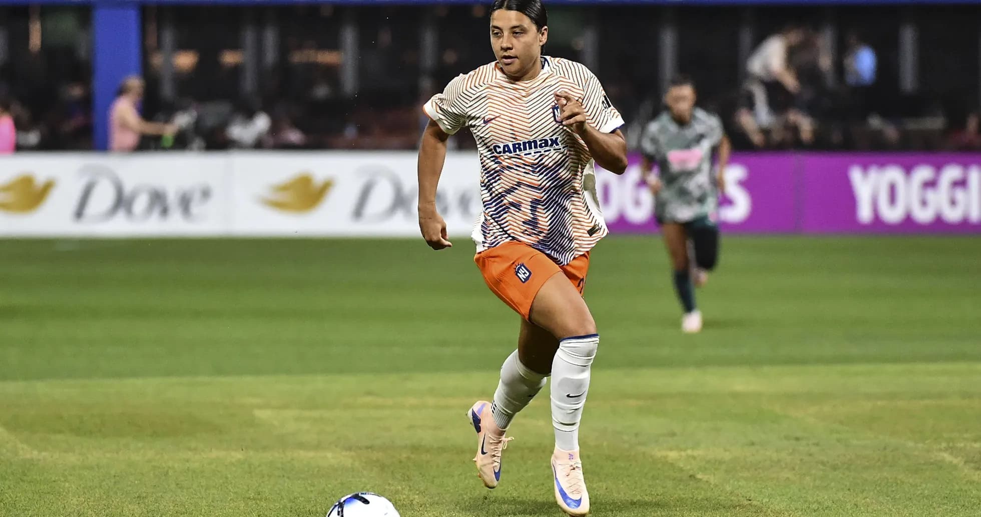Jugadora corriendo con el balón durante un partido Jugadora corriendo con el balón durante un partido