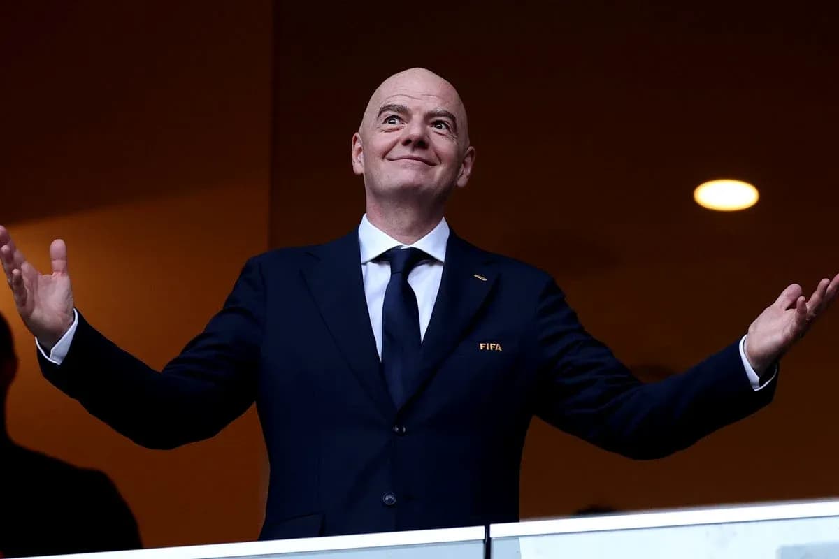 Persona en traje con logo de FIFA en palco Persona en traje con logo de FIFA en palco