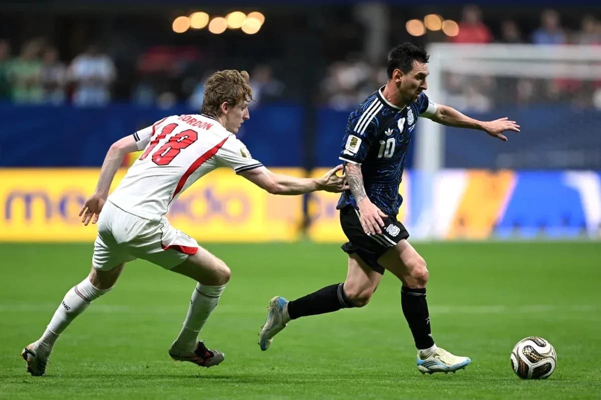 Jugador argentino driblando mientras es marcado por rival Jugador argentino driblando mientras es marcado por rival