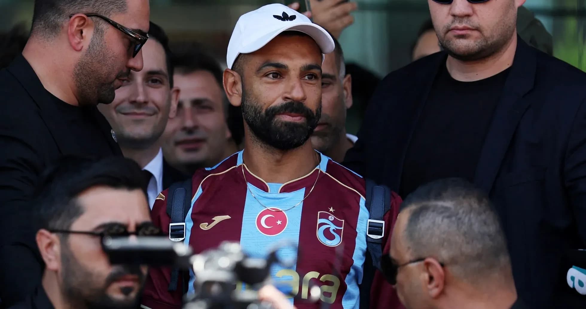 Jugador de Trabzonspor rodeado de seguridad en llegada Jugador de Trabzonspor rodeado de seguridad en llegada