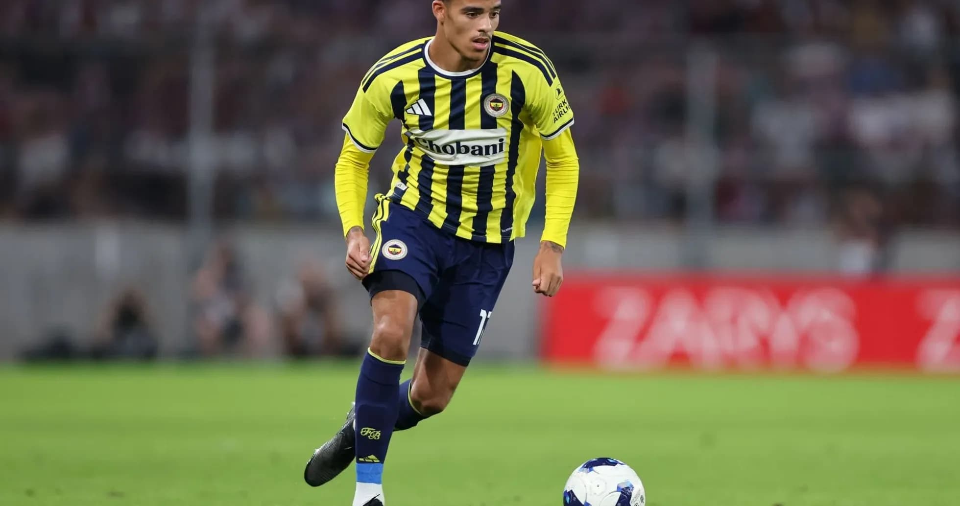 Jugador de Fenerbahçe con balón en el campo Jugador de Fenerbahçe con balón en el campo
