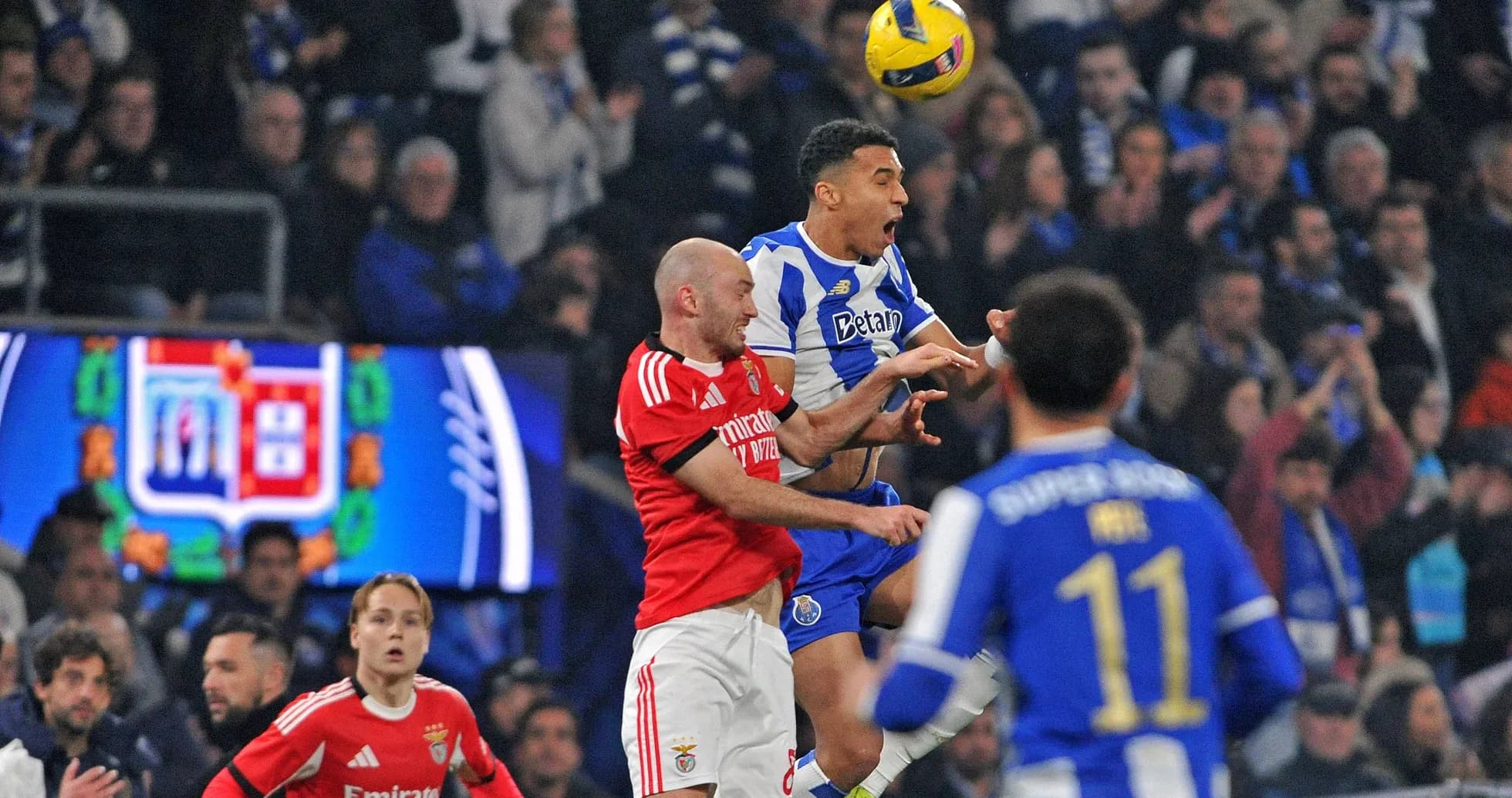 Jugadores de Porto y Benfica disputando un balón en el aire Jugadores de Porto y Benfica disputando un balón en el aire