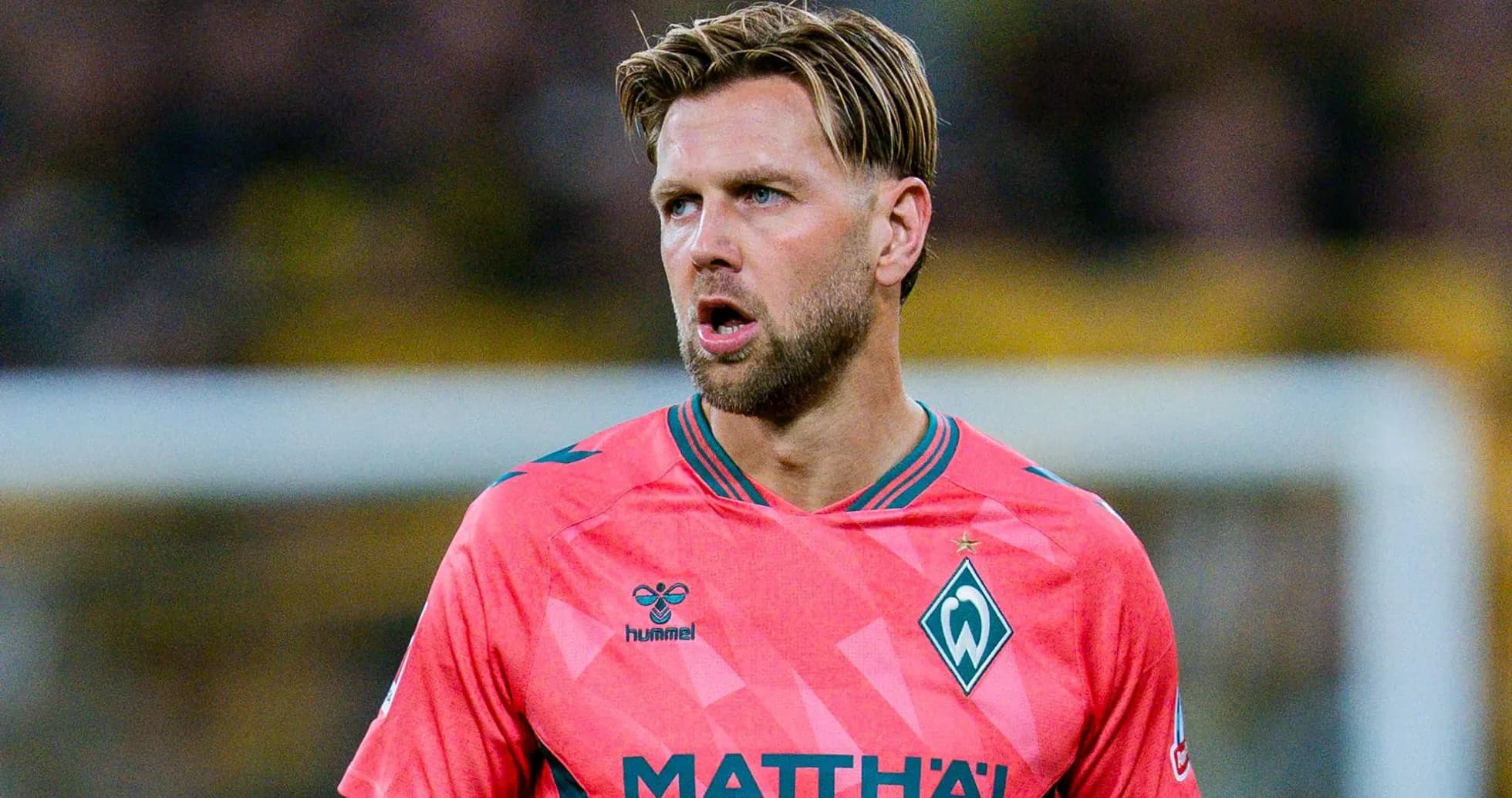Jugador de Werder Bremen en camiseta rosa durante partido Jugador de Werder Bremen en camiseta rosa durante partido