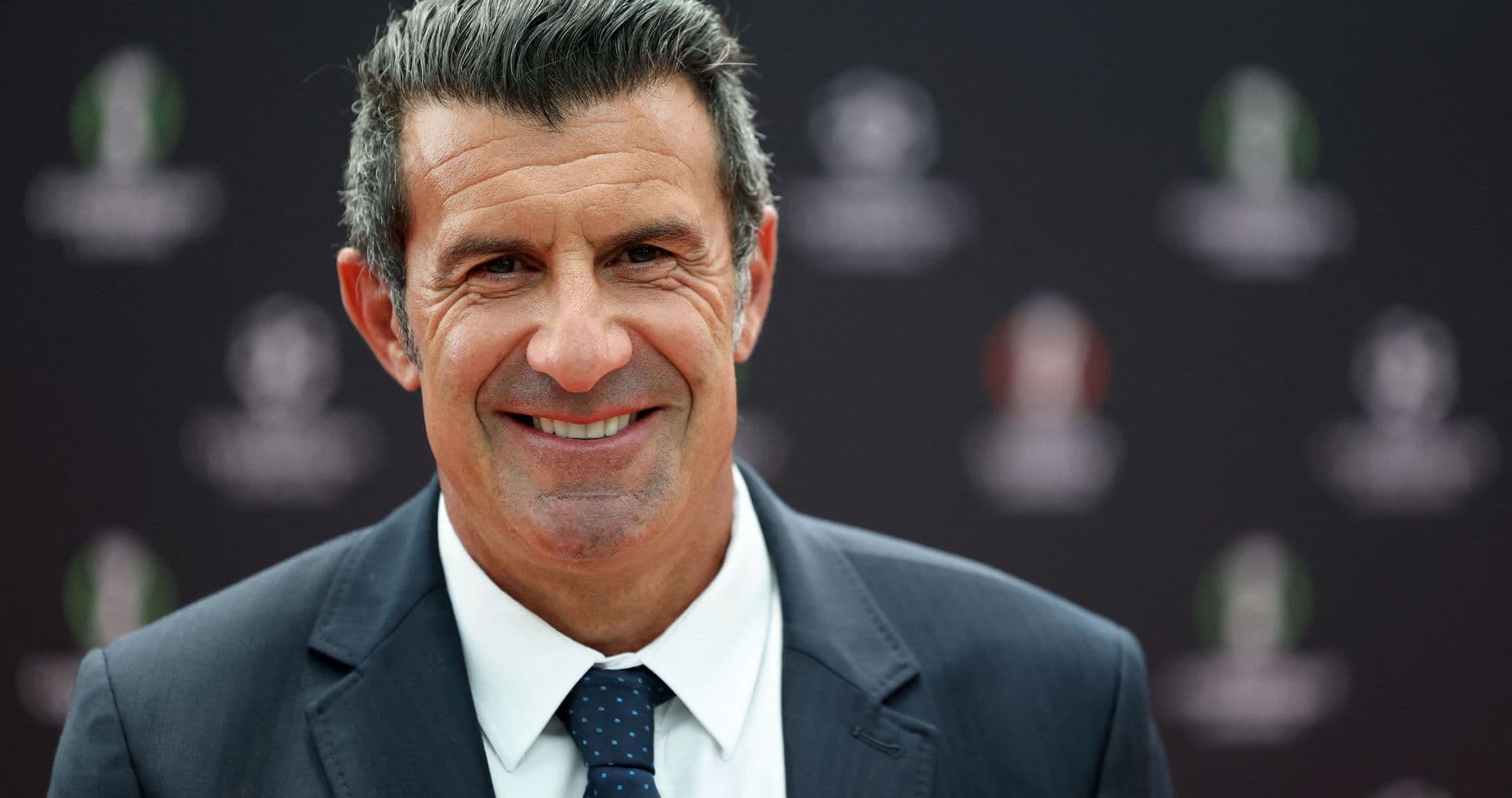 Hombre sonriendo en evento con fondo oscuro Hombre sonriendo en evento con fondo oscuro