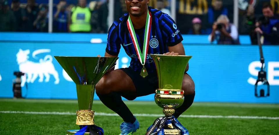 Jugador de Inter celebrando con trofeos en el campo Jugador de Inter celebrando con trofeos en el campo