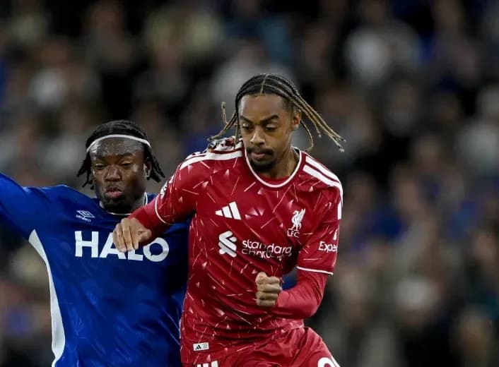 Jugador de Liverpool corriendo con balón ante rival Jugador de Liverpool corriendo con balón ante rival