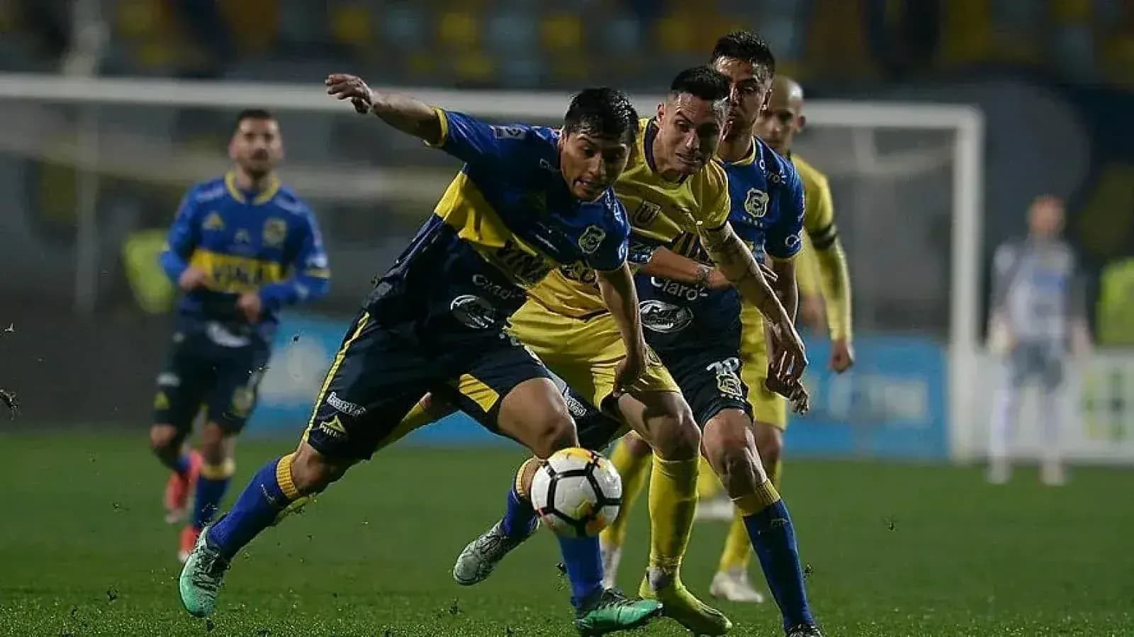 Jugadores compitiendo por el balón en el partido Jugadores compitiendo por el balón en el partido