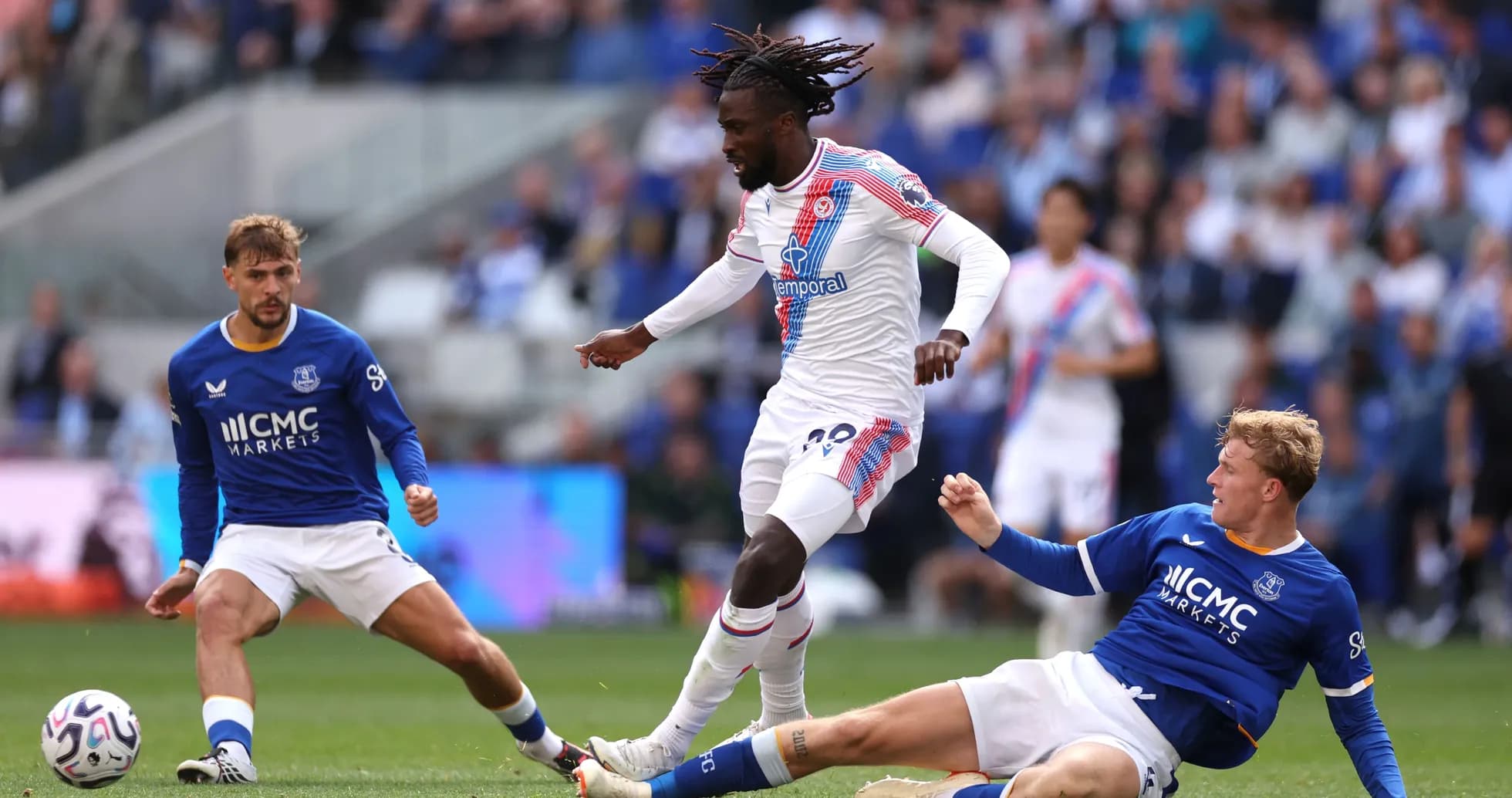 Jugador de Crystal Palace driblando entre dos rivales de Everton Jugador de Crystal Palace driblando entre dos rivales de Everton