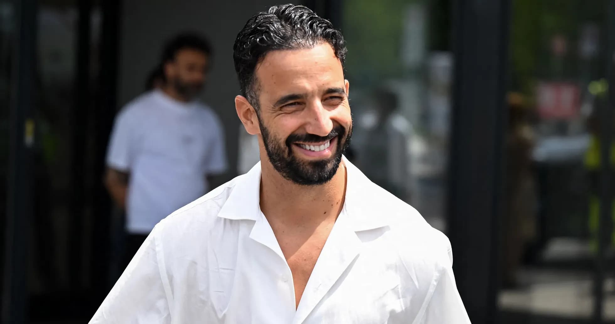 Jugador sonriendo al salir de un edificio Jugador sonriendo al salir de un edificio