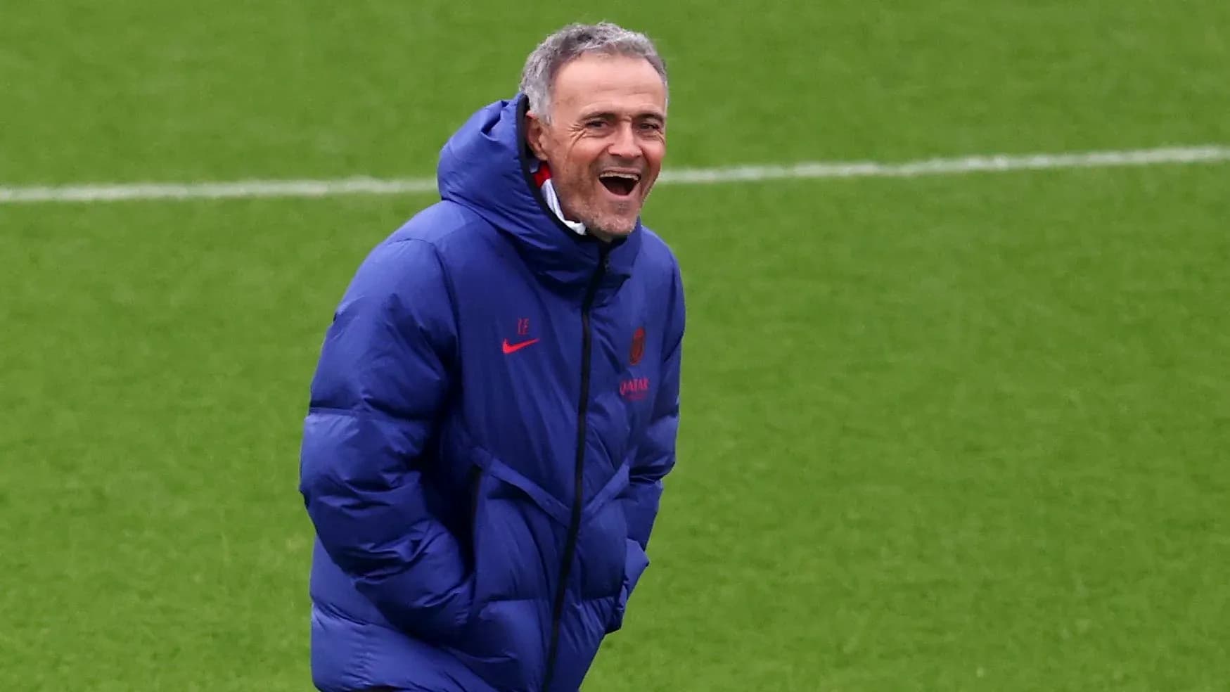Entrenador sonriente en el campo de entrenamiento Entrenador sonriente en el campo de entrenamiento