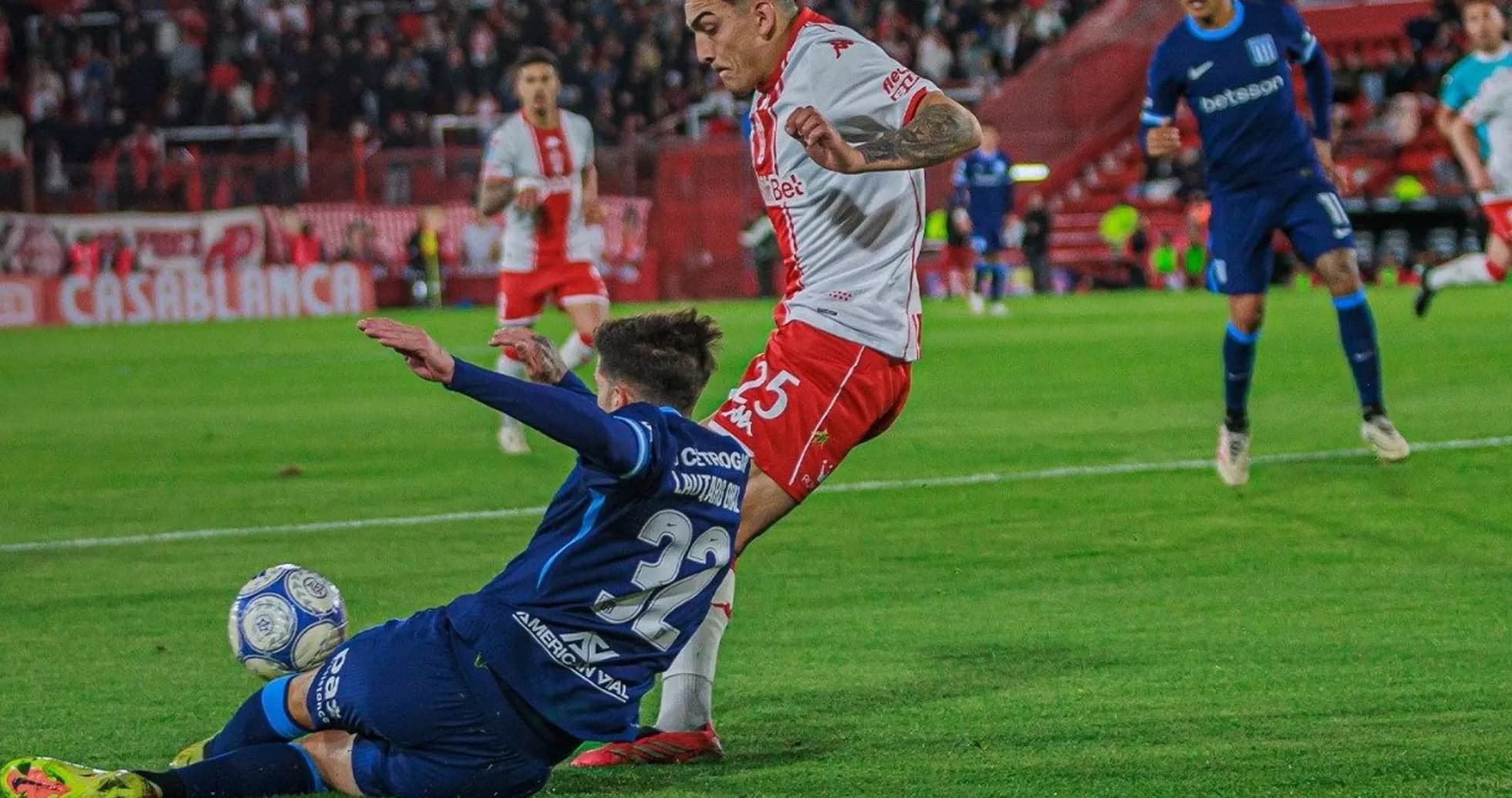 Jugador de Huracán esquivando una entrada de Racing Jugador de Huracán esquivando una entrada de Racing