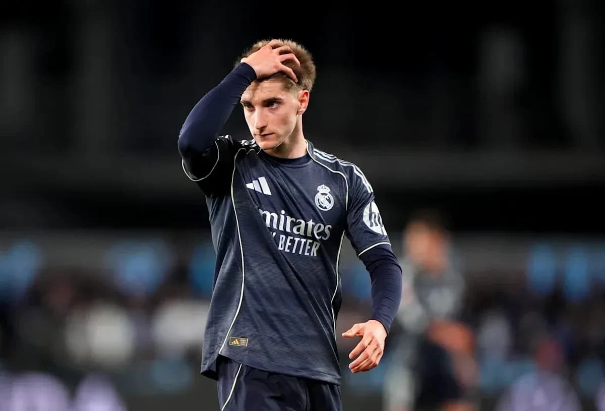 Jugador de Real Madrid tocándose la cabeza en el campo Jugador de Real Madrid tocándose la cabeza en el campo