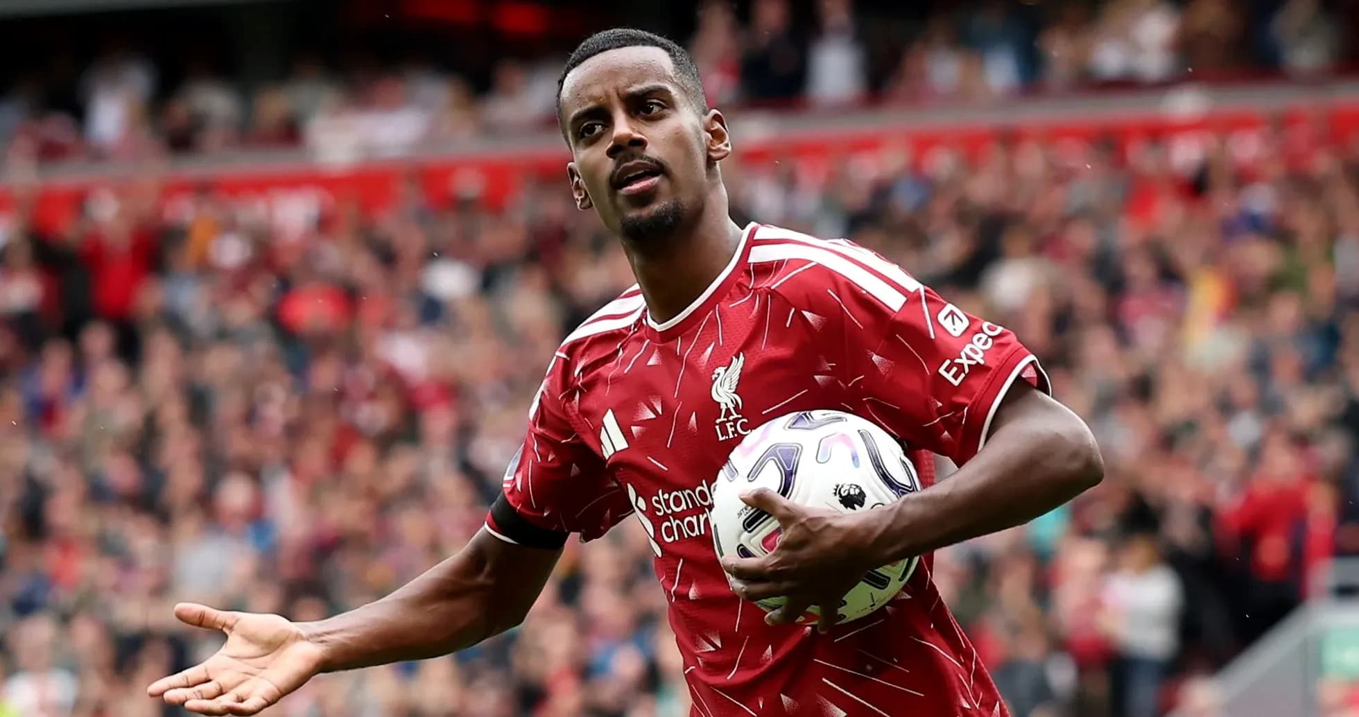 Jugador de Liverpool sosteniendo el balón en el campo Jugador de Liverpool sosteniendo el balón en el campo