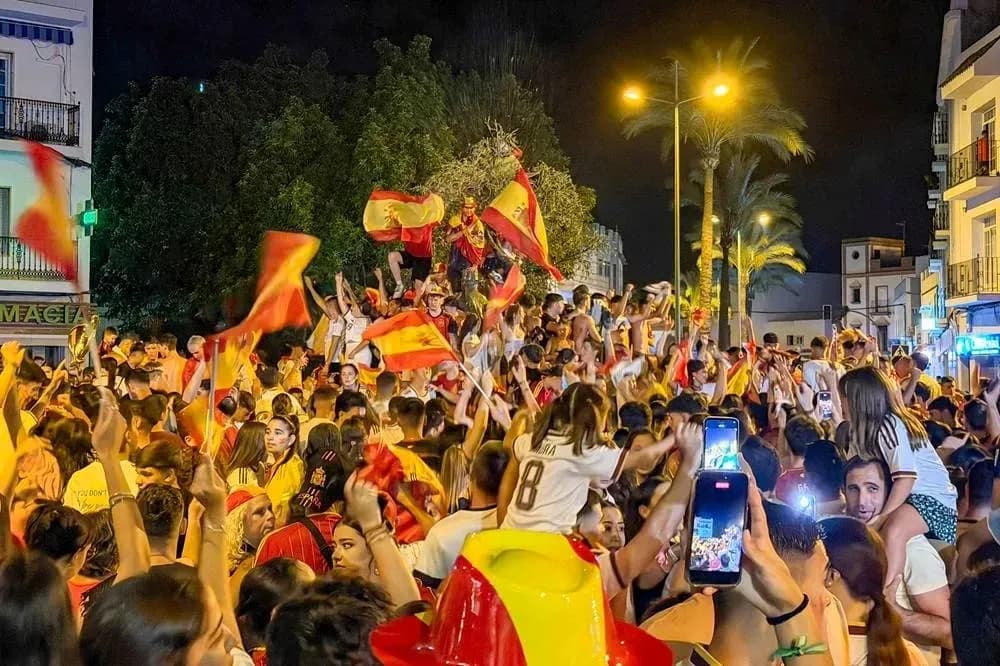 Multitud celebrando con banderas en la noche Multitud celebrando con banderas en la noche