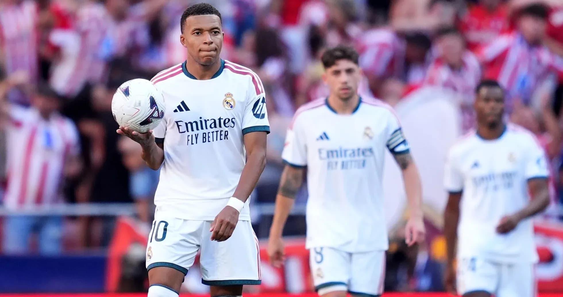 Kylian Mbappé sosteniendo el balón en el campo Kylian Mbappé sosteniendo el balón en el campo