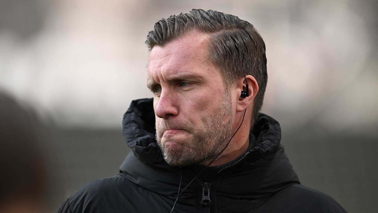 Entrenador con auriculares en el campo de entrenamiento Entrenador con auriculares en el campo de entrenamiento