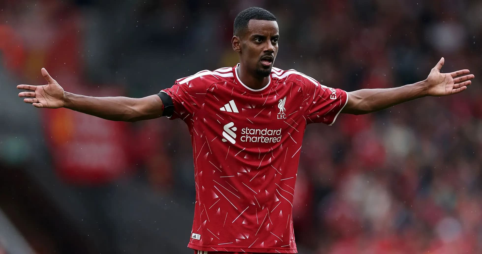 Jugador de Liverpool con los brazos extendidos en el campo Jugador de Liverpool con los brazos extendidos en el campo