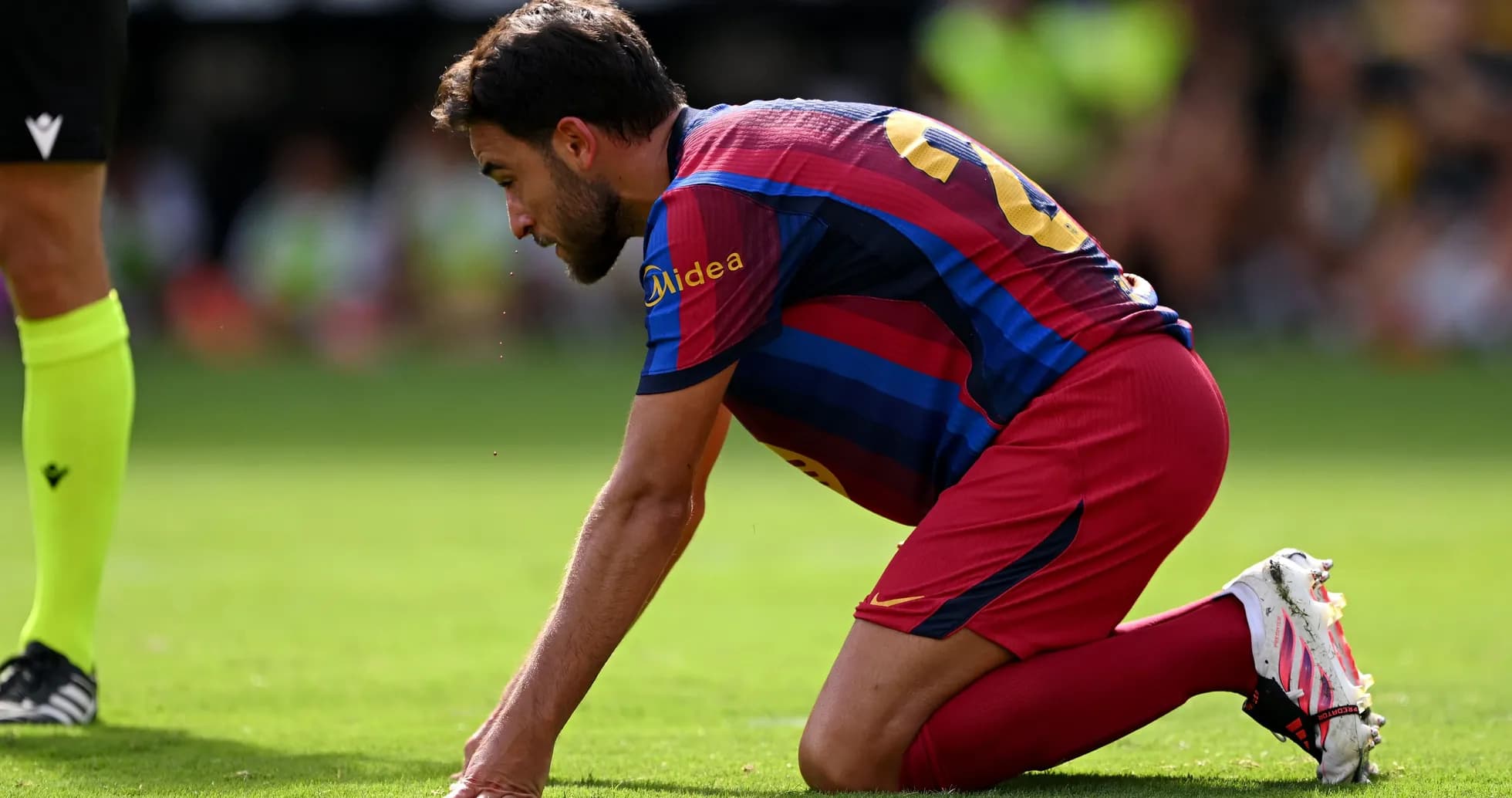 Jugador de Barcelona arrodillado en el campo Jugador de Barcelona arrodillado en el campo