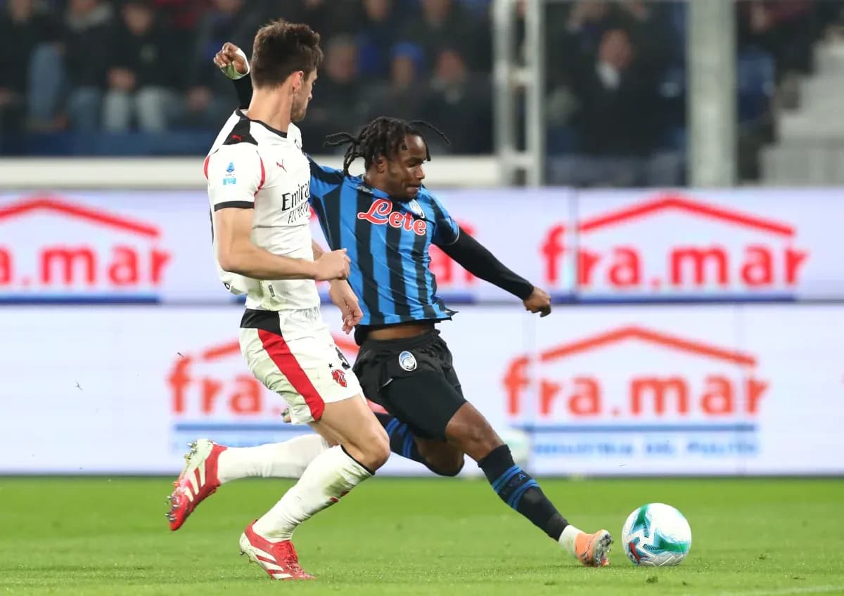 Jugador de Atalanta driblando a defensor de AC Milan Jugador de Atalanta driblando a defensor de AC Milan