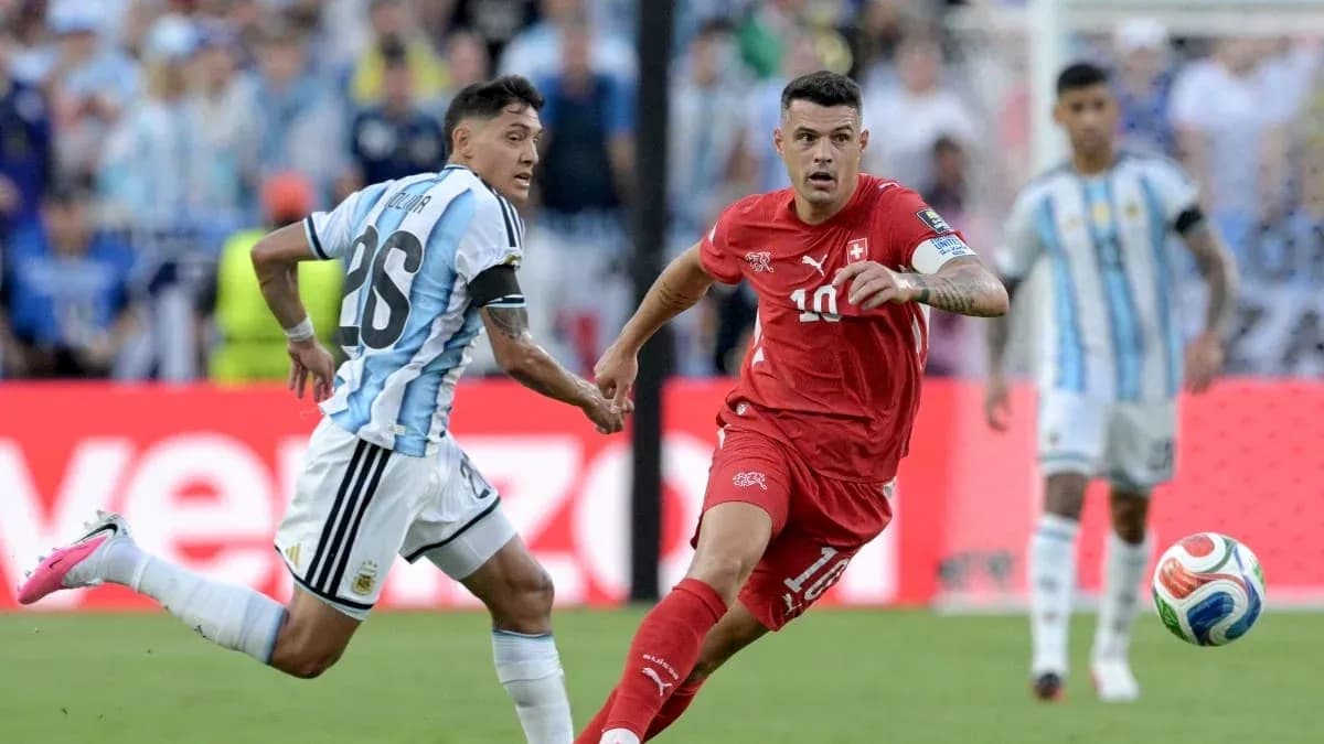 Jugador suizo driblando mientras es marcado por argentino Jugador suizo driblando mientras es marcado por argentino