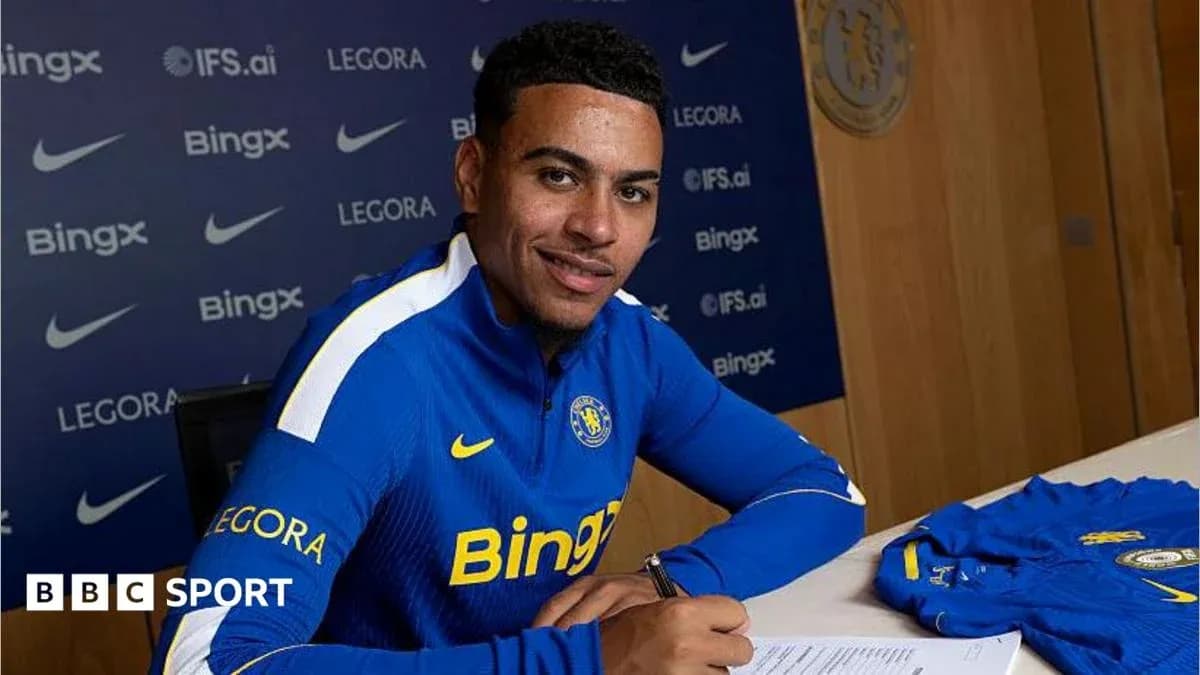 Jugador firmando contrato en mesa con camiseta Jugador firmando contrato en mesa con camiseta