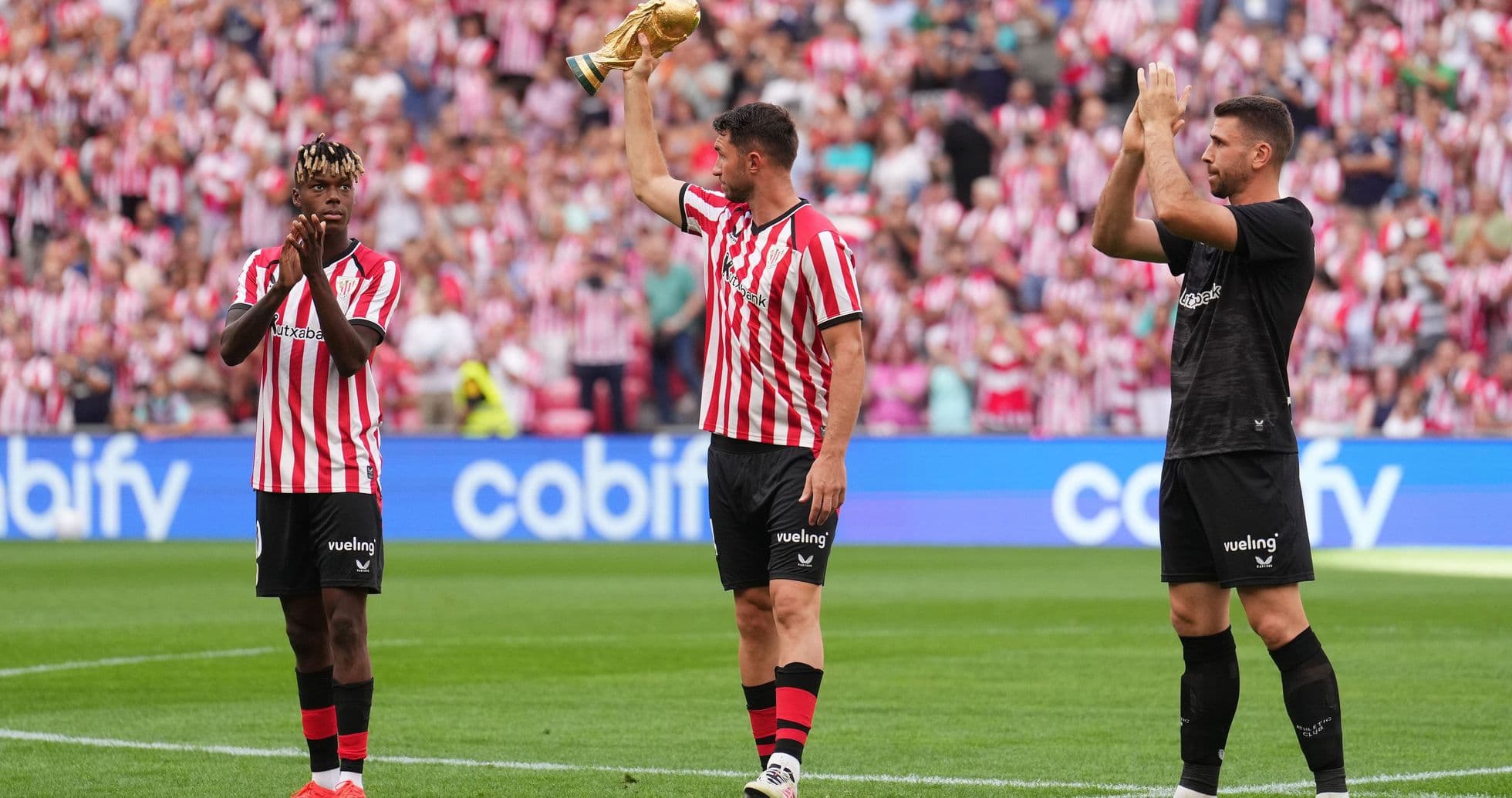 Jugadores de Athletic Club celebrando con trofeo en el campo Jugadores de Athletic Club celebrando con trofeo en el campo