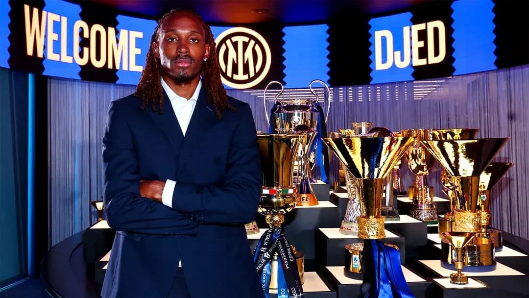 Jugador posando frente a trofeos en presentación Jugador posando frente a trofeos en presentación