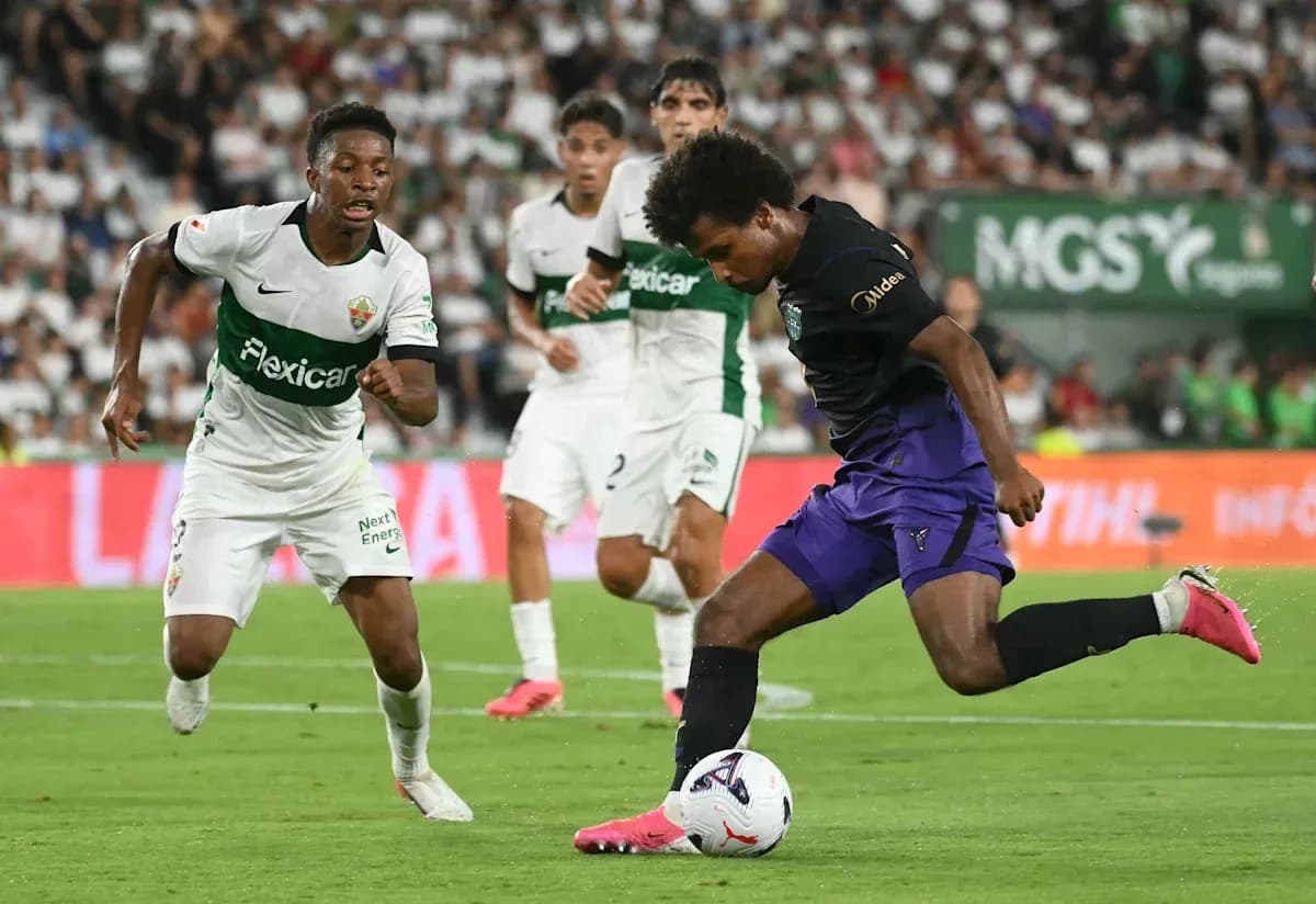 Jugador de Elche persiguiendo a rival con balón Jugador de Elche persiguiendo a rival con balón