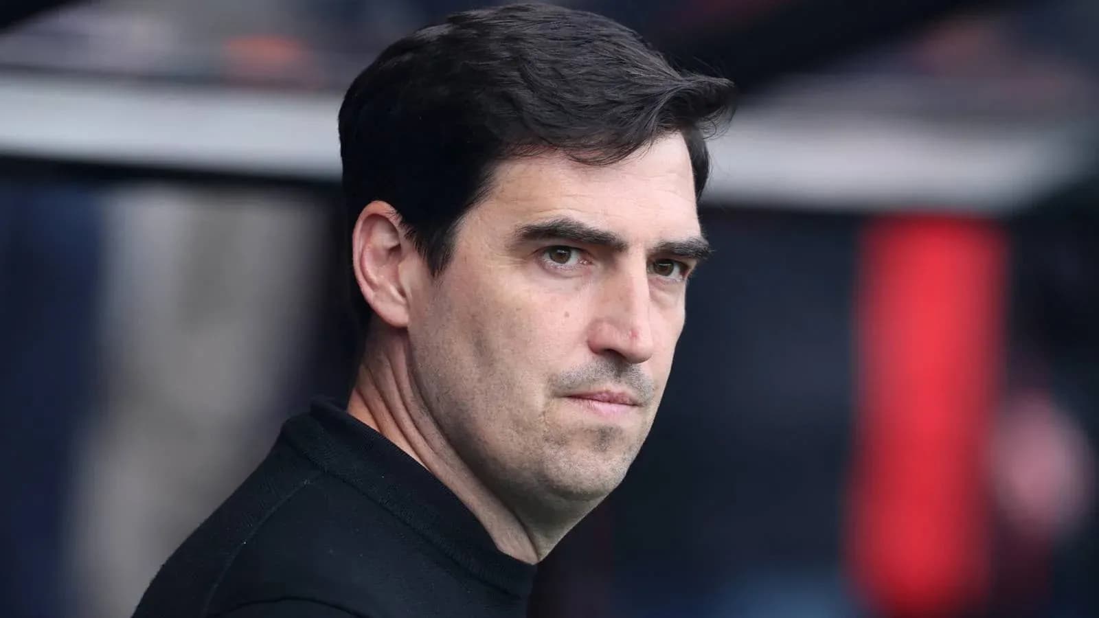 Entrenador observando el partido desde el banquillo Entrenador observando el partido desde el banquillo
