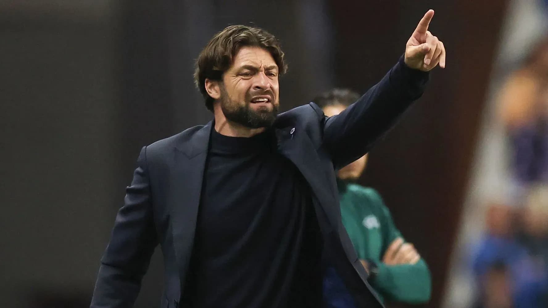 Entrenador dirigiendo a su equipo desde la línea lateral Entrenador dirigiendo a su equipo desde la línea lateral
