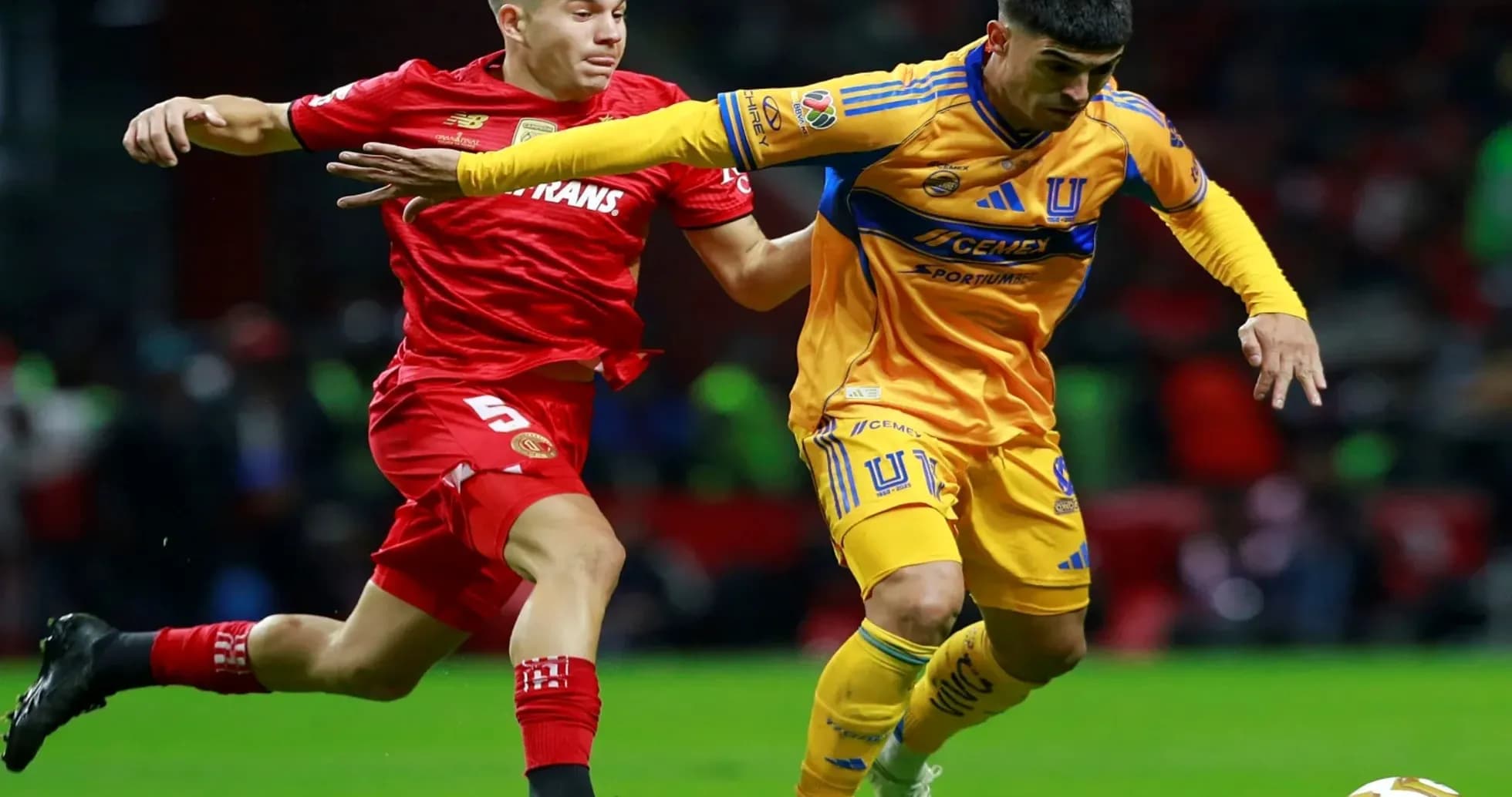 Jugadores de Toluca y Tigres compiten por el balón Jugadores de Toluca y Tigres compiten por el balón