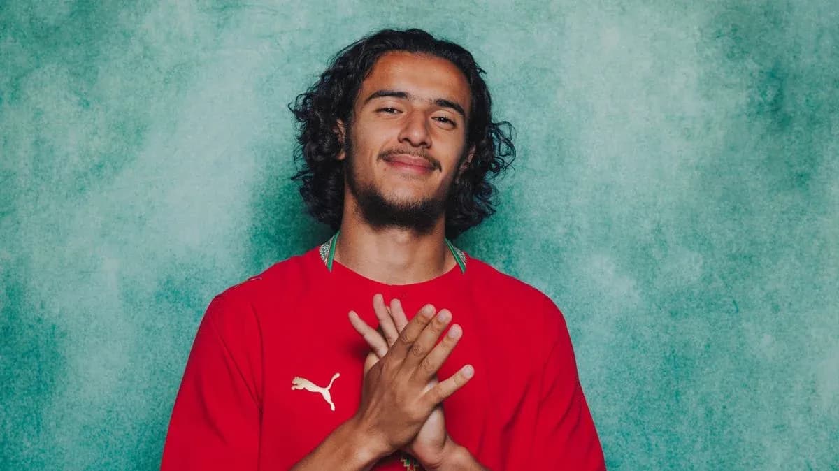 Jugador con camiseta roja sonriendo en fondo verde Jugador con camiseta roja sonriendo en fondo verde