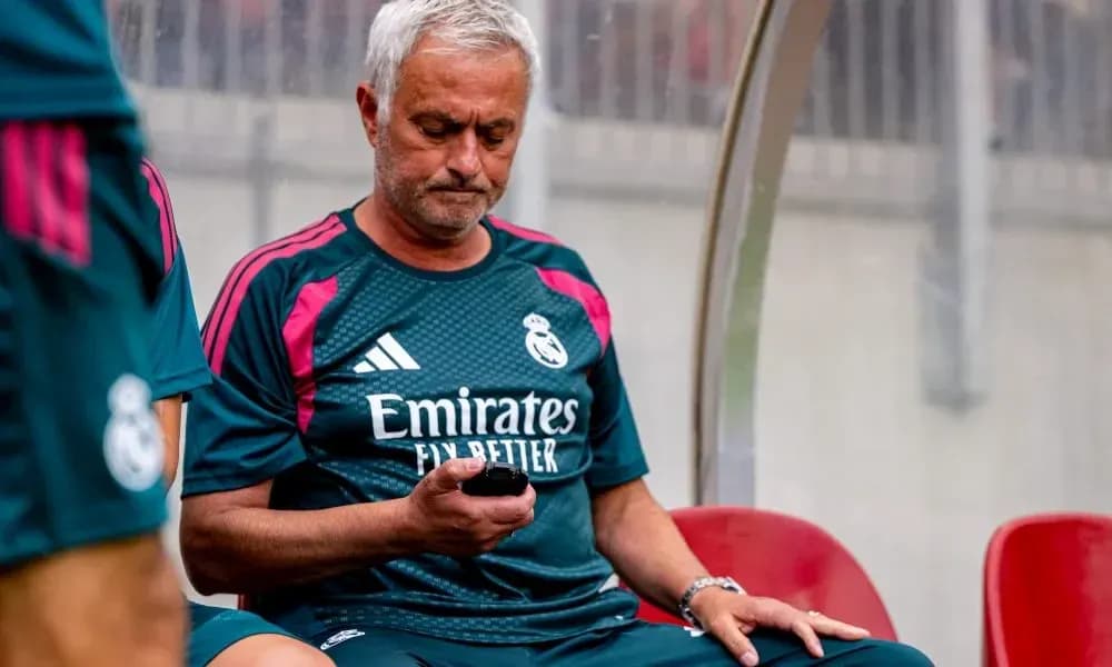 Entrenador de Real Madrid revisando su teléfono en el banquillo Entrenador de Real Madrid revisando su teléfono en el banquillo