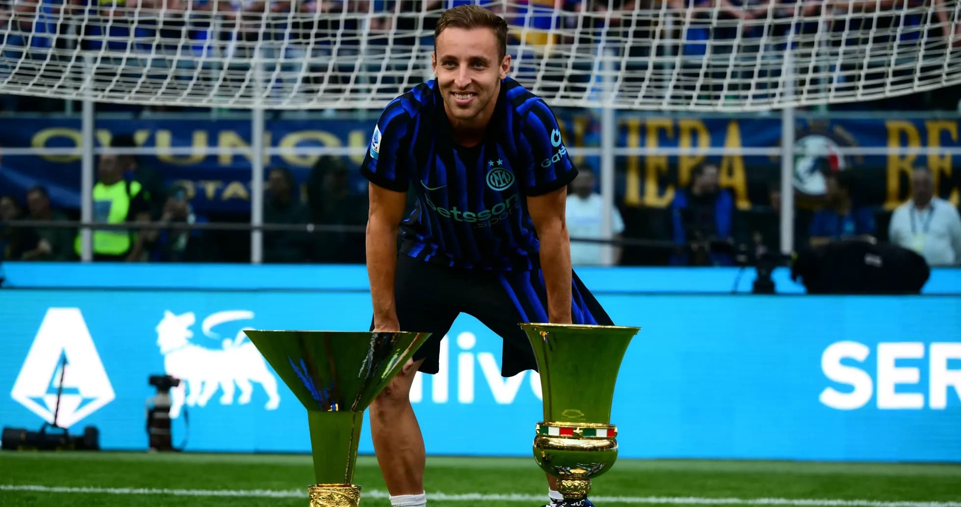 Jugador de Inter celebrando con trofeos en el campo Jugador de Inter celebrando con trofeos en el campo