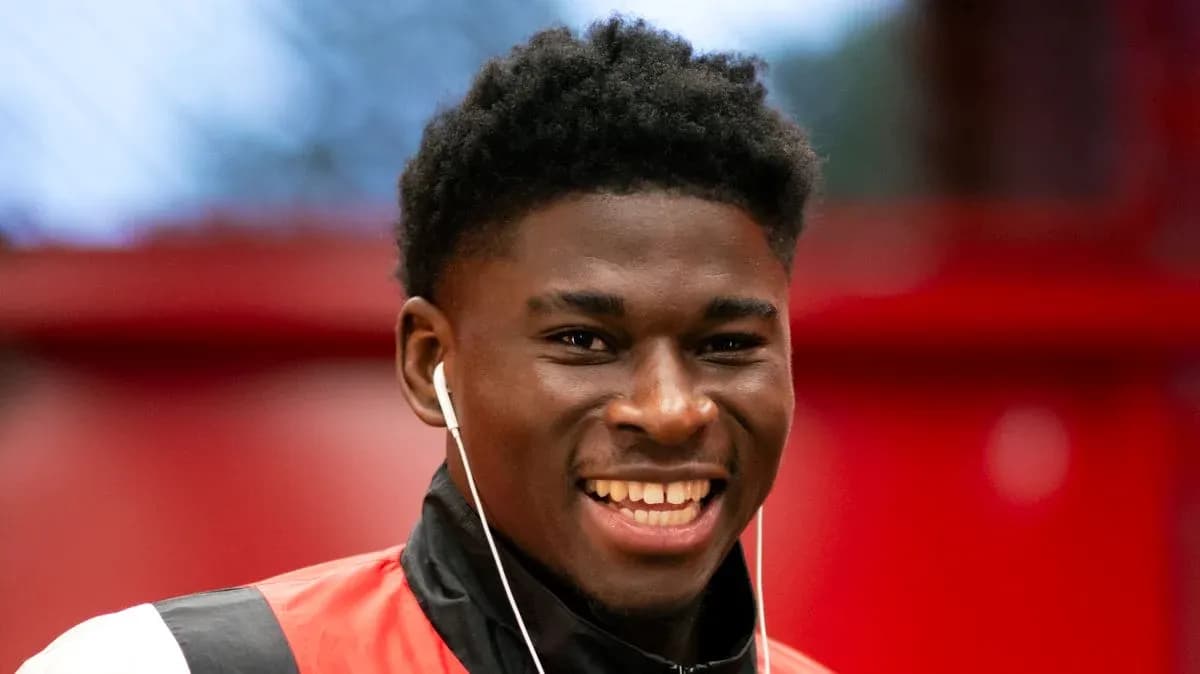 Jugador sonriendo con auriculares en un vestuario Jugador sonriendo con auriculares en un vestuario