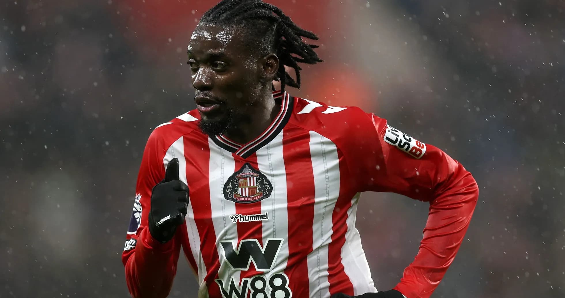 Jugador de Sunderland corriendo en la lluvia Jugador de Sunderland corriendo en la lluvia