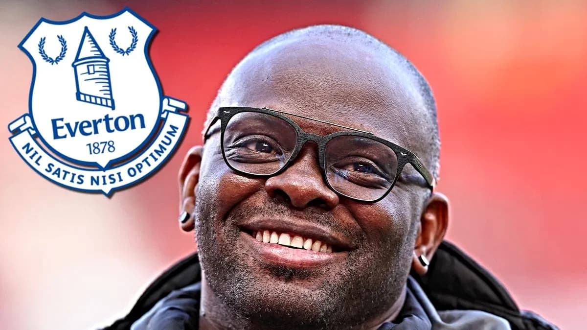 Hombre sonriendo con gafas junto al escudo de Everton Hombre sonriendo con gafas junto al escudo de Everton