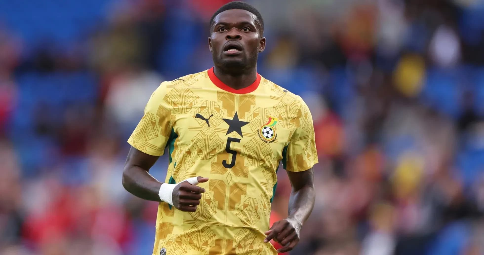 Jugador de Ghana en uniforme amarillo durante partido Jugador de Ghana en uniforme amarillo durante partido